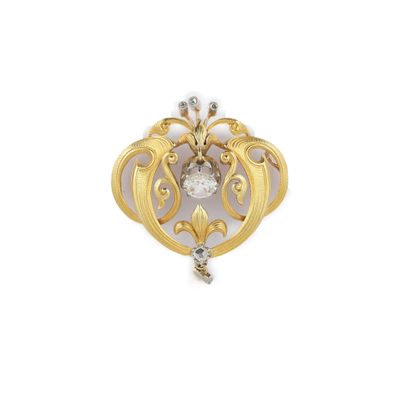 un gros plan d'une broche en or et diamants sur fond blanc