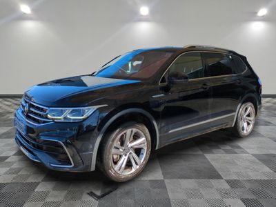 un SUV Volkswagen noir garé sur un sol à damier dans un showroom