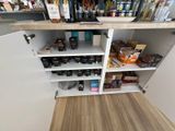 a white cabinet with a lot of food and drinks on it