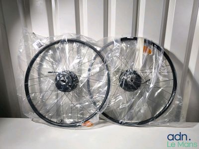 une paire de roues de vélo dans des sacs en plastique, posées sur une surface blanche