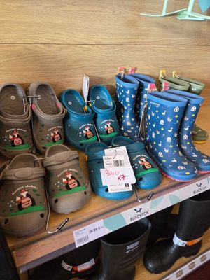 several pairs of children ' s shoes are on a shelf in a store