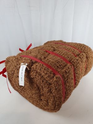 un ours en peluche enveloppé dans de la laine marron et orné d'un ruban rouge