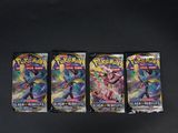 trois paquets de cartes à collectionner Pokémon posés sur une surface noire