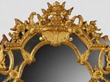 a mirror that has a gold frame with angels on it
