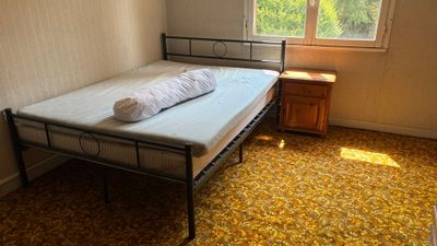 un petit lit dans un coin d'une pièce dotée d'une fenêtre