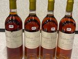 four bottles of wine are lined up on a table