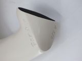 a white vase with a black top on a white surface