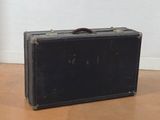a black suitcase sitting on the floor next to a white wall