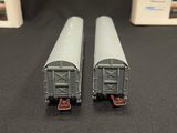 two train cars sitting next to each other on a table