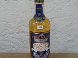 une bouteille d'alcool posée sur une table près d'un mur blanc