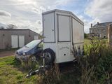 une petite remorque garée dans l'herbe