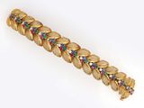 a close up of a gold bracelet with multi colored stones