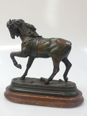 bronze statue of a horse on a wooden base on a white background