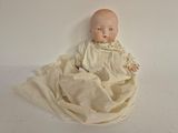 a baby doll that is laying on a blanket