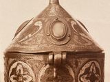 an old photo of a silver box with a cross on it