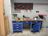 un établi dans un garage, sur lequel sont posés de nombreux outils