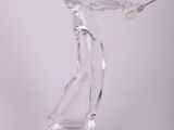 clear glass figurine of a man holding a golf club on a clear surface