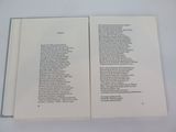 an open book with a poem on it sitting on top of a table