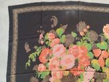 a black scarf with a bunch of flowers on it