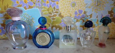 trois flacons de parfum différents posés sur un plan de travail