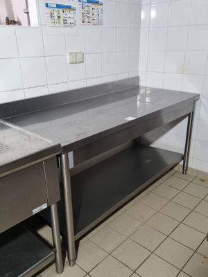 deux éviers en acier inoxydable dans une cuisine aux murs carrelés
