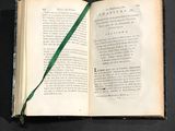 an open book with a green ribbon on top of it