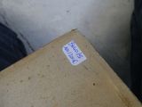 une boîte en carton avec un autocollant posé sur le sol