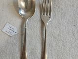 deux cuillères et une fourchette en argent sur une table