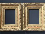 two gold frames on a blue wall with a black background