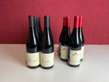 four bottles of wine are lined up on a table