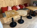 three tables and two stools in the corner of the room