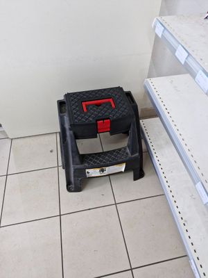 a small step stool in the middle of a tiled floor