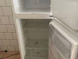 a white refrigerator with a door open on a tiled floor
