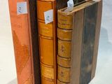 trois livres posés l'un à côté de l'autre sur une surface blanche