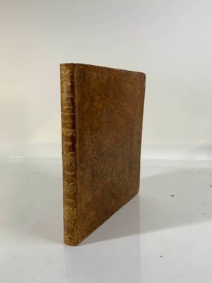 an old book sitting on top of a table next to a white wall