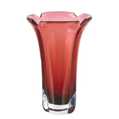 un vase en verre rouge bordé de noir, posé sur une surface blanche