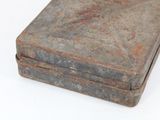 an old metal box that is sitting on a white surface