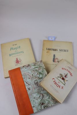 Trois livres sont posés sur une surface blanche ; l'un est orange et l'autre est vert.