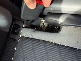 a hand that is holding a piece of paper in the seat of a car