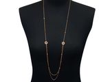 a black mannequin torso with a gold chain and two gold circles on it