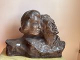 a statue of a man and a woman sitting on a rock