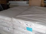 a stack of mattresses sitting on a pallet in a warehouse