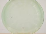 an image of a green glass plate on a stand on a wooden table