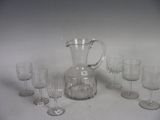 a lot of wine glasses and a pitcher on the table