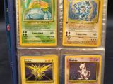 four pokemon cards are in a blue case on a table