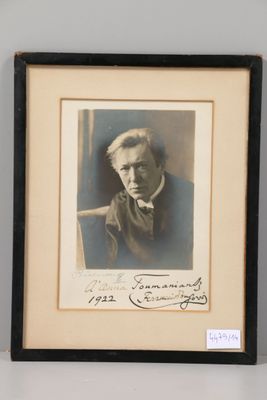 an old photo of a man in a suit and tie sitting in a chair