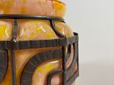 a yellow and black vase with a black handle