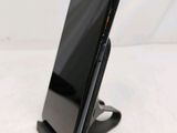 a close up of a cell phone on a stand on a table