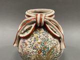 a vase with a bow on the top of it