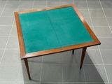 une petite table au plateau vert posée sur un sol carrelé